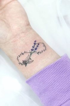 a woman's wrist with a flower tattoo on it