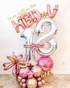 a happy birthday balloon arrangement with the number twenty eight in pink, gold and silver