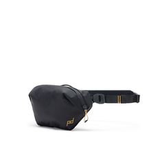 a black fanny bag with gold details on the front and shoulder strap, sitting against a white background