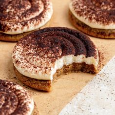 several cookies with white frosting and chocolate sprinkles on them sitting on a table