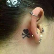 a person with a skull and crossbone tattoo behind their ear