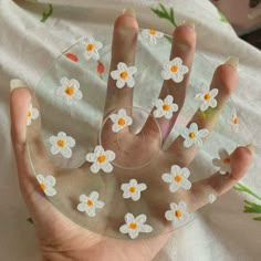 a person's hand holding a glass plate with flowers on it