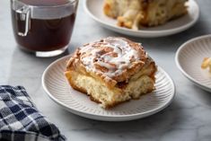 three plates with pastries on them next to a cup of tea and a napkin