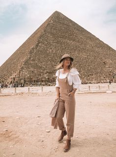 a woman standing in front of the great pyramid