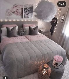 a bedroom decorated in grey and pink with lights