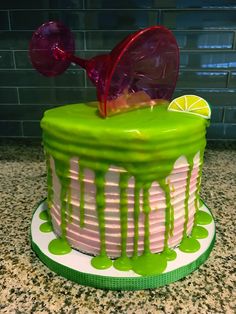 a green and white cake with lime drizzled on the top, sitting on a counter