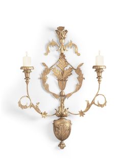 an ornately decorated wall light with two candles on each arm and one candle in the middle