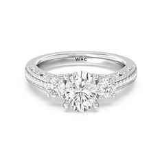 a three stone engagement ring with two side stones on the band and a round diamond center