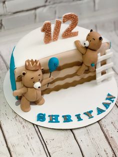 a birthday cake with two teddy bears on top and the number 12 in the middle