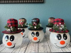 three snowmen with hats on their heads sitting on a table