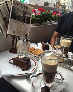 a man sitting at a table with desserts and drinks