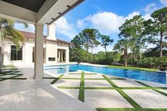 an outdoor swimming pool with grass on the ground and trees in the backgroud