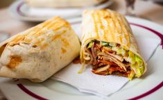 a burrito cut in half sitting on top of a plate