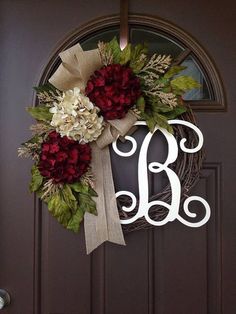 a monogrammed wreath is hanging on the front door