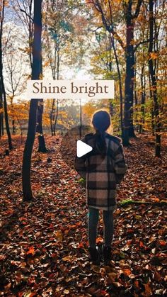 a person standing in the woods with leaves on the ground and text that reads shine bright