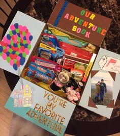 an open gift box filled with toys and personalized cards on top of a table