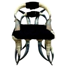 an animal's skull chair with horns on the back and black seat pad, against a white background