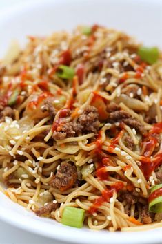 a white bowl filled with noodles and meat