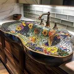 a bathroom sink that is made out of glass and has flowers painted on the side