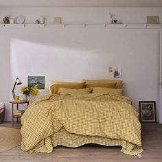 a bed with yellow and white checkered comforter in a room next to a window