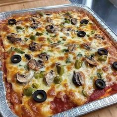 a pizza with mushrooms, peppers and olives in a pan