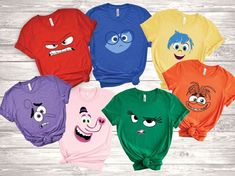 five different colored shirts with cartoon faces on them