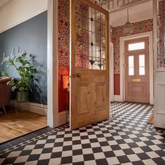 an open door in a room with black and white checkered flooring