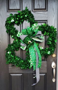 a green wreath on the front door with shamrocks and ribbons hanging from it's sides