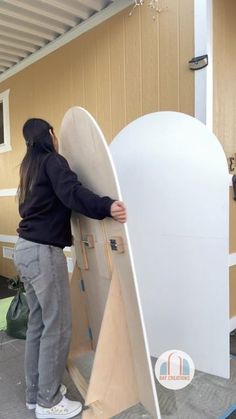 a woman standing next to a surfboard in a garage