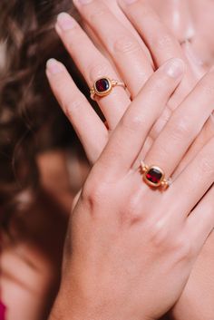 This handcrafted ring features a deep red garnet, elegantly set in a rich gold bezel, beautifully contrasting with the slender silver band. The delicate gold accents on either side of the garnet add a playful touch, creating a more casual feel. This piece can easily be combined with a casual oufit or really be accentuated by combining it with a red or black cocktail dress. Sterling silver  Gold vermeil  Garnet  To properly care for your silver jewellery, there are a few important steps you shoul Gold Garnet Ring, Sustainable Accessories, Red Or Black, August Birthstone Jewelry, July Birthstone Jewelry, Garnet Ring, Black Cocktail, Jewelry Ring Box, Handcrafted Rings