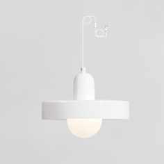 a white light hanging from the ceiling with an electrical plug attached to it's end