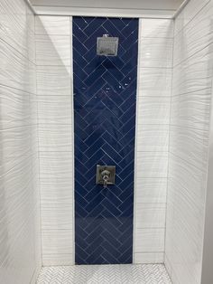 a blue and white tiled shower stall in a bathroom