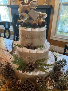 a three tiered diaper cake decorated with deer and pine cones