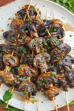 skewered meat and vegetables on a plate with parsley garnishes