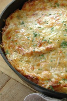 a cheesy casserole in a pan on a wooden table