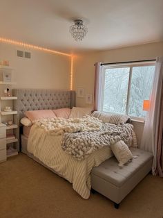 a bedroom with a large bed and a chandelier hanging from it's ceiling