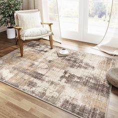 a living room area with a chair, rug and window in the background that has white curtains