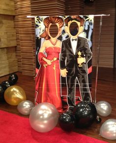 a party decoration with balloons and an image of two people in formal attire on it