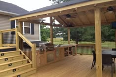 a wooden deck with grill and table on it