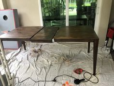 a wooden table sitting on top of a white sheeted floor next to an open door