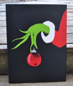 an image of a hand holding a christmas ornament on a black card board