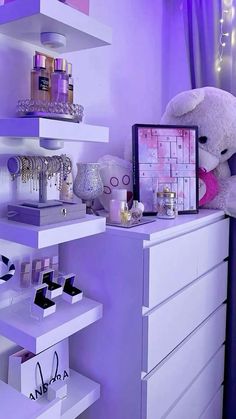 a white teddy bear sitting on top of a dresser next to a purple shelf filled with cosmetics