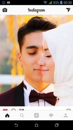 a man and woman kissing each other while wearing tuxedos in front of them