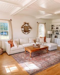 a living room filled with furniture and a large rug on top of a hard wood floor