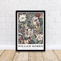 the william morris book cover is shown on a wooden floor in front of a white brick wall