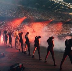 several people standing in front of a crowd at a concert