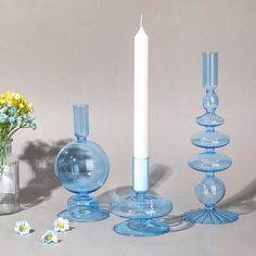 blue glass candlesticks and vases with flowers in them