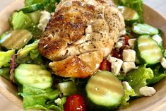 a salad with chicken and cucumbers in a wooden bowl