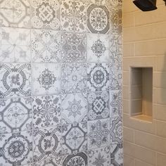 a bathroom with a tiled wall and white tiles on the shower walls, along with a toilet