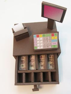 a miniature cash register with money in it